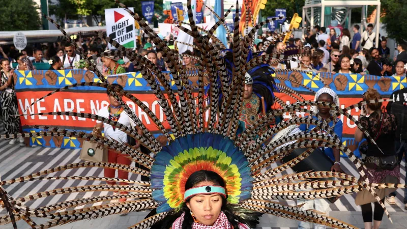 Žena v kostýmu se zúčastnila protestu proti "klimatické nespravedlnosti" v Dubaji během konference COP28