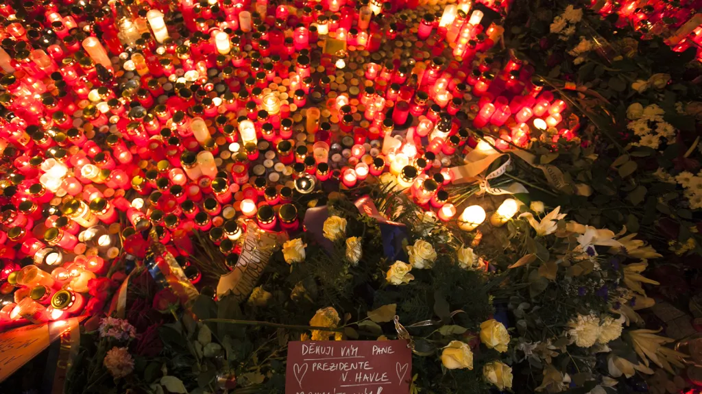 Zapálené svíčky a květiny na Národní třídě