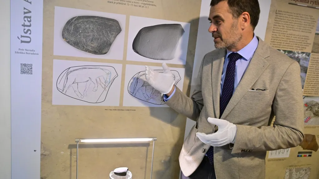 Archeolog Petr Neruda ukazuje rytinu koně a mamuta