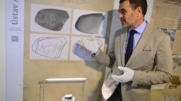 Archeolog Petr Neruda ukazuje rytinu koně a mamuta