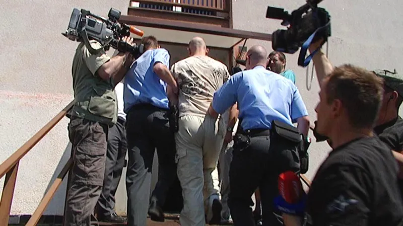Policisté odvádějí stíhaného cizince