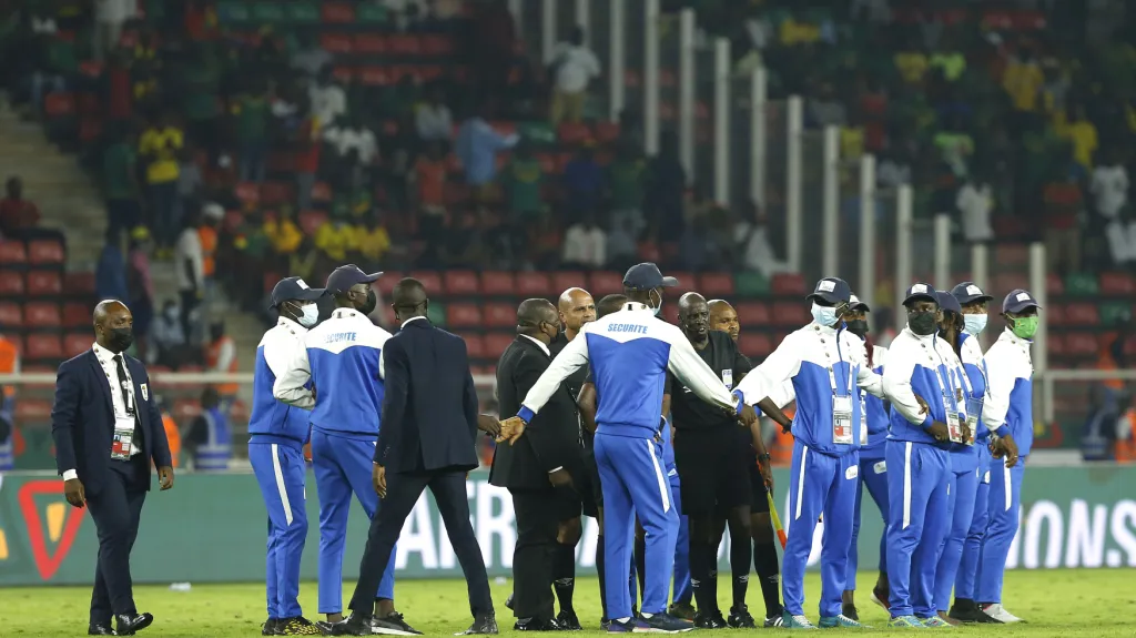 Pracovníci ochranky kolem hráčů během utkání mezi Kamerunem a Komorami