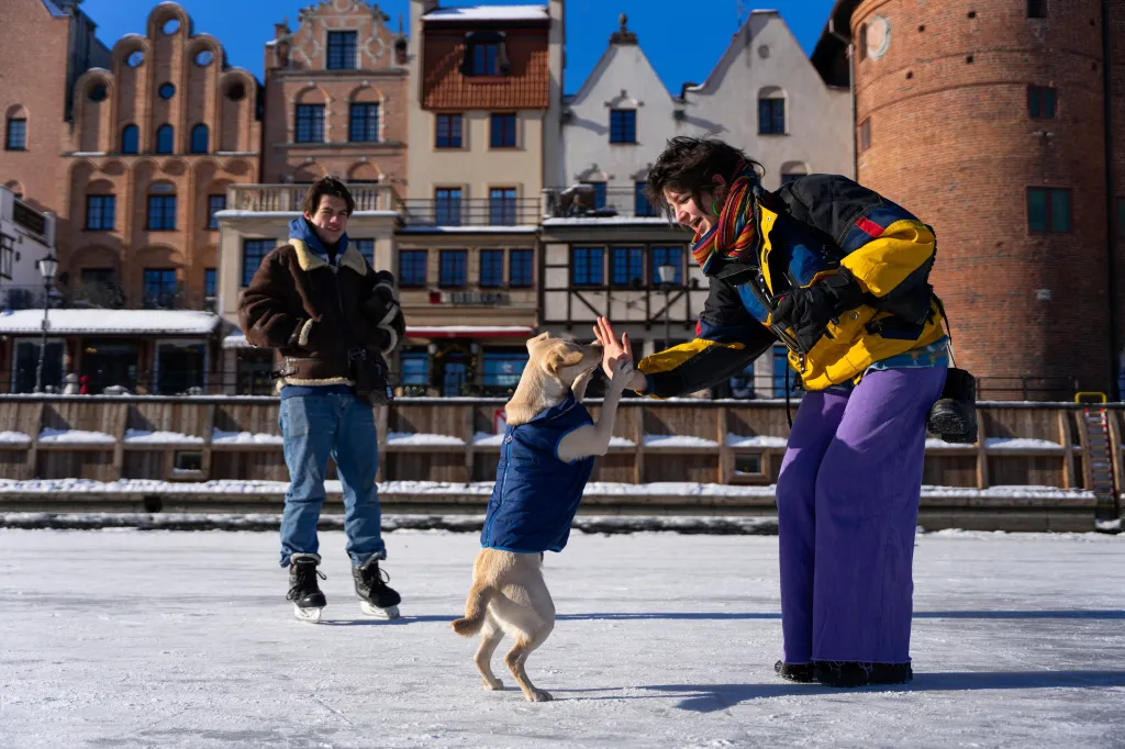 Žena si hraje se psem na zamrzlé řece Motlawě v polském Gdaňsku