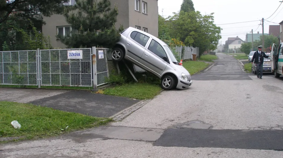 Toyota zaparkovaná na plotě