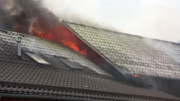 Plameny zachvátily střechu autoservisu