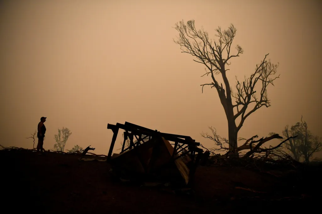 John Aish prochází zničeným místem, kde stál jeho dům, zatímco ohně dále ničí Nový Jižní Wales