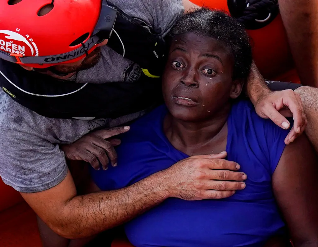 Člen záchranného týmu neziskovky Proactiva Open Arms uklidňuje ženu z Kamerunu bezprostředně po její záchraně z vod Středozemního moře. Josepha byla nalezena v hlubokém šoku. Doktorům později vypověděla, že strávila noc zavěšená na zbytky ztroskotané lodi zpíváním kamerunské hymny a modlením se k bohu.