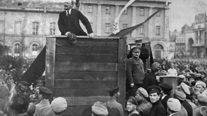 Lenin při projevu na nedatovaném snímku. Vpravo vedle tribuny Trockij, který byl později z fotografie vyretušován