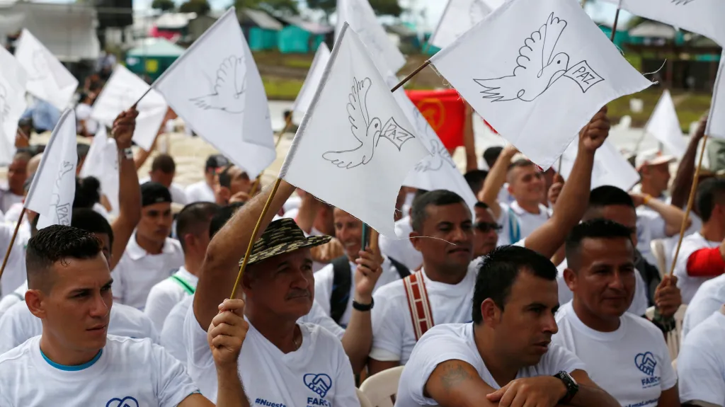Stoupenci hnutí FARC mávají vlajkami při odzbrojování
