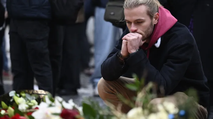 Muž u pietního místa před Karolinem za oběti střelby na Filozofické fakultě Univerzity Karlovy