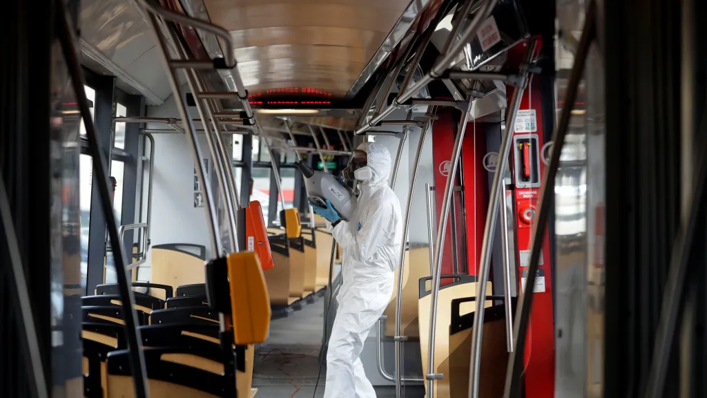 Pracovník v ochranném obleku dezinfikuje tramvaj, Praha (12. březen 2020)