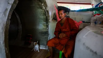 Buddhistický mnich sedí vedle svého psa v protiatomovém krytu v thajském Surinu