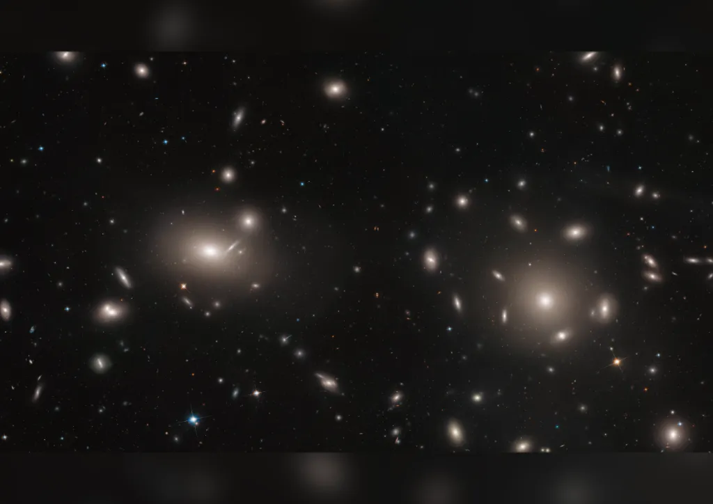 Tisíce galaxií ležící uprostřed takzvané kupy galaxií. Všechny jsou na sebe gravitačně vázané. Díky tomu mohou astronomové odhadnout, jak je v takových místech hmota rozložená. Právě podobná pozorování odhalila existenci takzvané temné hmoty. Jinak totiž nejde vysvětlit gravitační anomálie pozorované v takovýchto galaktických kupách