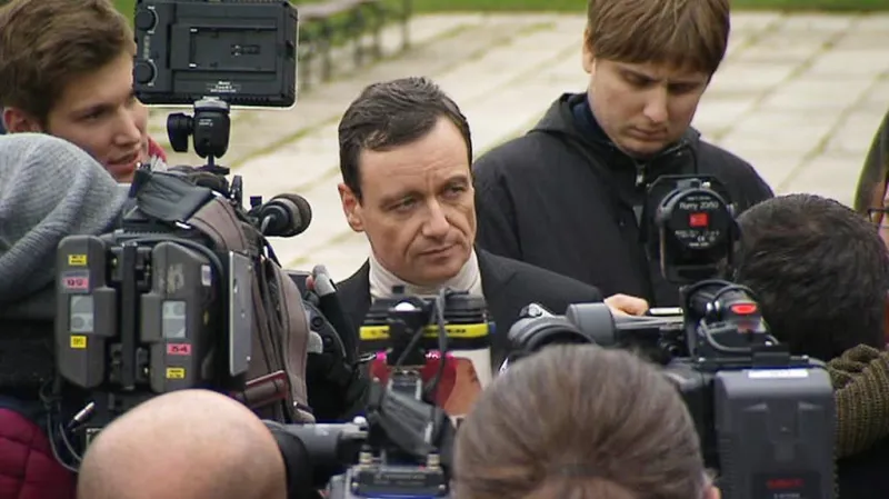 Rath mluví k novinářům na náměstí v Hostivici