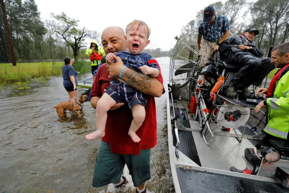 Jednoroční chlapec Oliver Kelly v náruči místního šerifa při záchraně ohrožených lidí během povodní způsobených hurikánem Florence v Severní Karolíně