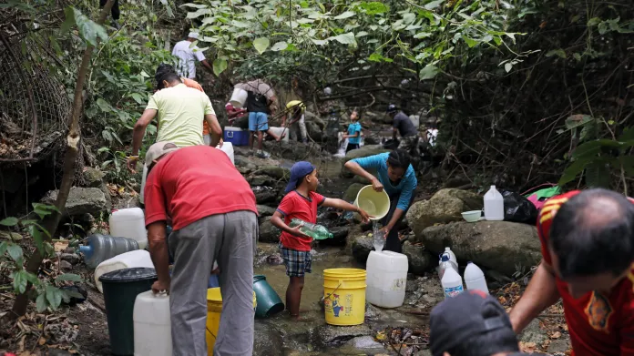 Obyvatelé Caracasu si chodí pro vodu do řeky tekoucí městem
