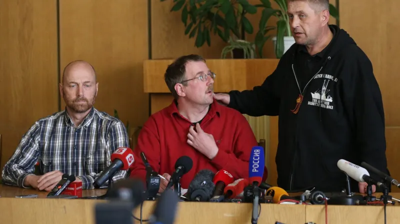 Člen pozorovatelské mise Axel Schneider (úplně vlevo) a Vjačeslav Ponomarov (úplně vpravo) na tiskové konferenci