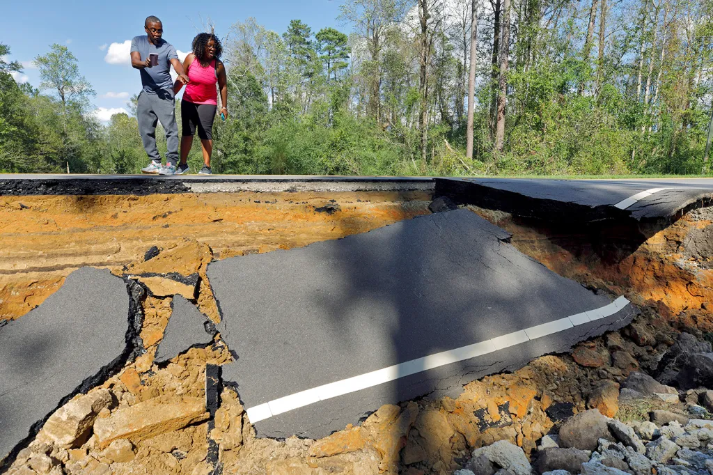 Kolemjdoucí přihlížejí sesuvu podmáčené silnice způsobeném tropickou bouří Florence v Severní Karolíně