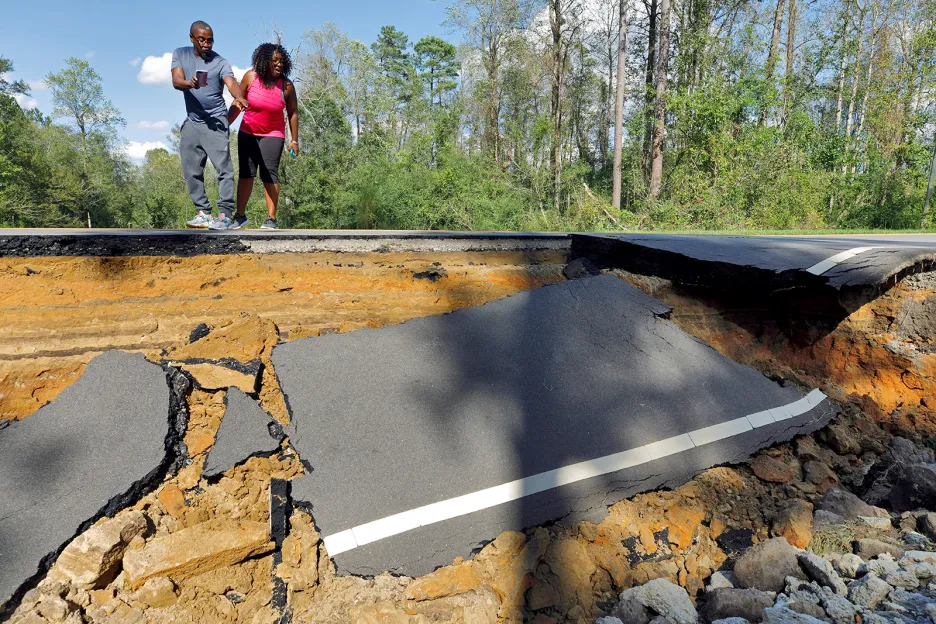 Kolemjdoucí přihlížejí sesuvu podmáčené silnice způsobeném tropickou bouří Florence v Severní Karolíně