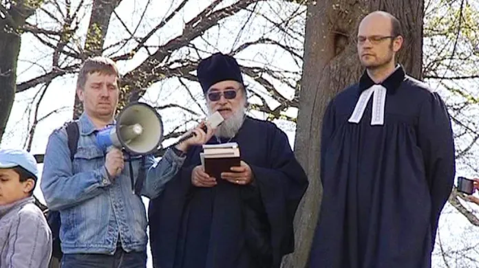Farář Ludvík Šťastný (uprostřed) při bohoslužbě v Krupce