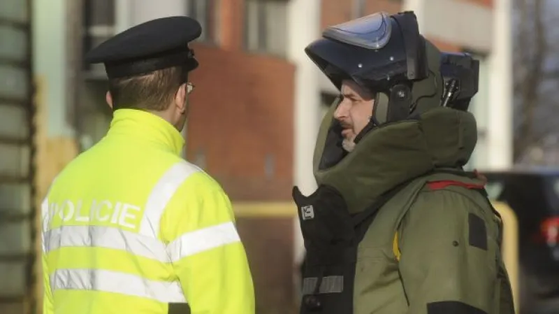 Policisté vynášejí zbraně a výbušniny ze 45. budovy