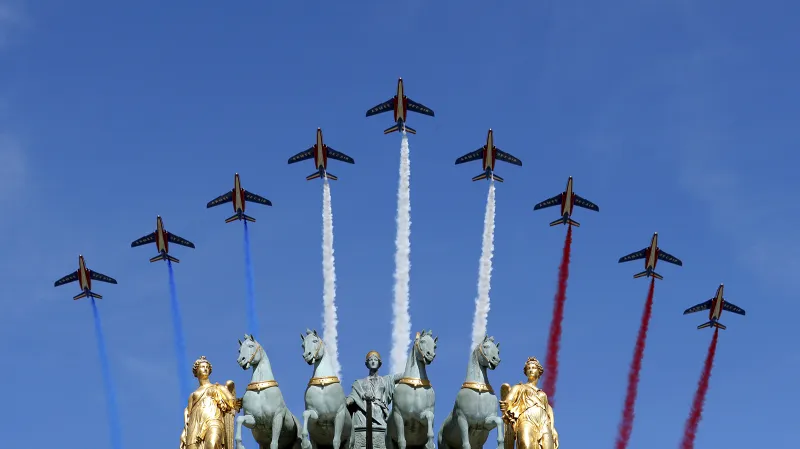 Stíhací letouny nad Vítězným obloukem vypouštějí kouřovou trikoloru ve francouzských barvách při vojenské přehlídce u příležitosti výročí pádu Bastily
