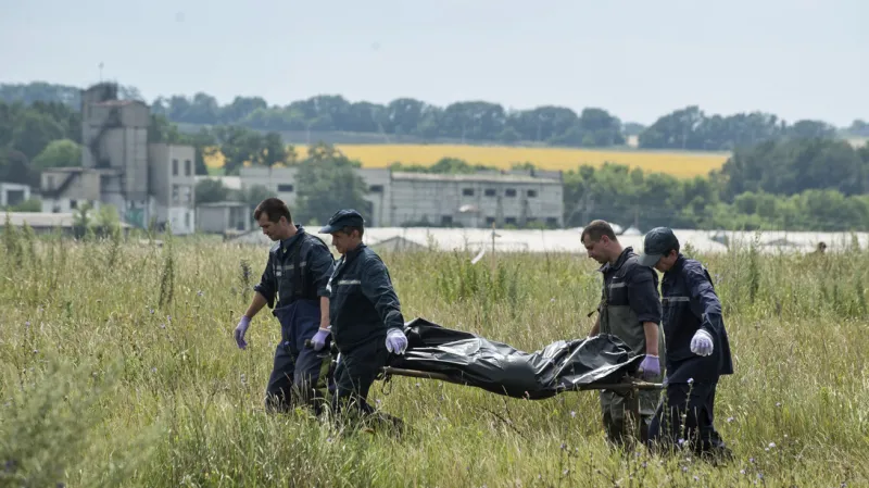 Záchranáři odnášejí oběti z malajsijského letadla