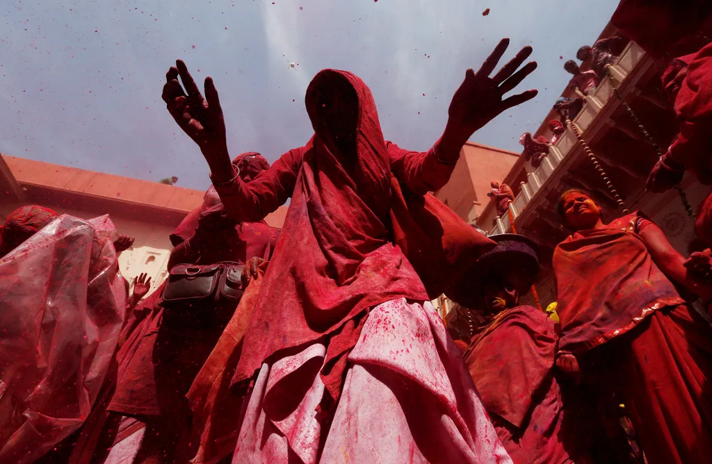 Vdovy v červených šatech a s červenou barvou po těle při účasti na festivalu Holi v indickém městě Vrindavan