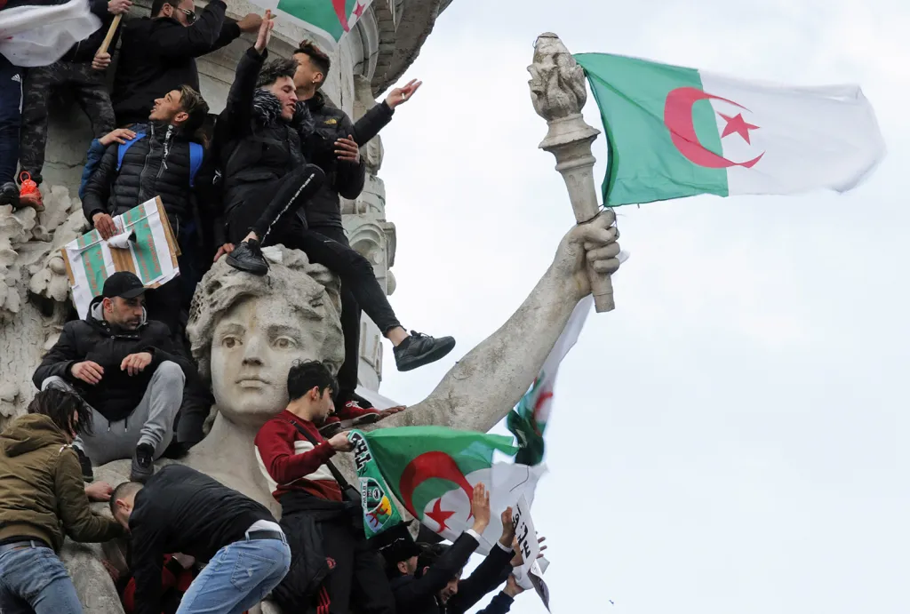 Demonstranti s alžírskými vlajkami při protestu proti prezidentu Bouteflikovi na náměstí Place de la Republique v Paříži