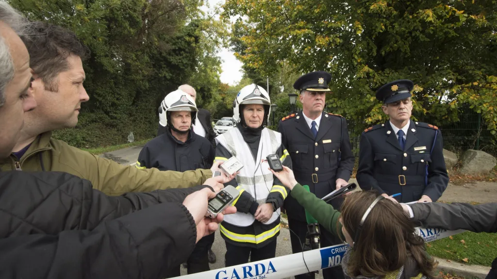 Zástupci policie a hasičů nedaleko místa požáru