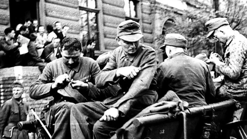 Vojáci SS na ústupu odstraňují z uniforem označení, identifikující jejich příslušnost