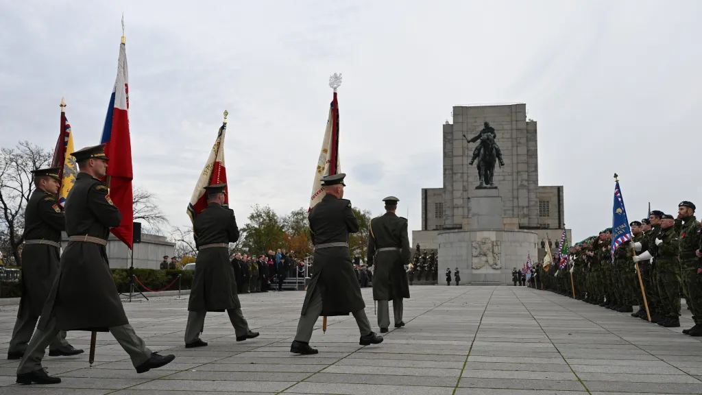 Vojáci slavnostně pochodující před Národním památníkem na pražském Vítkově.