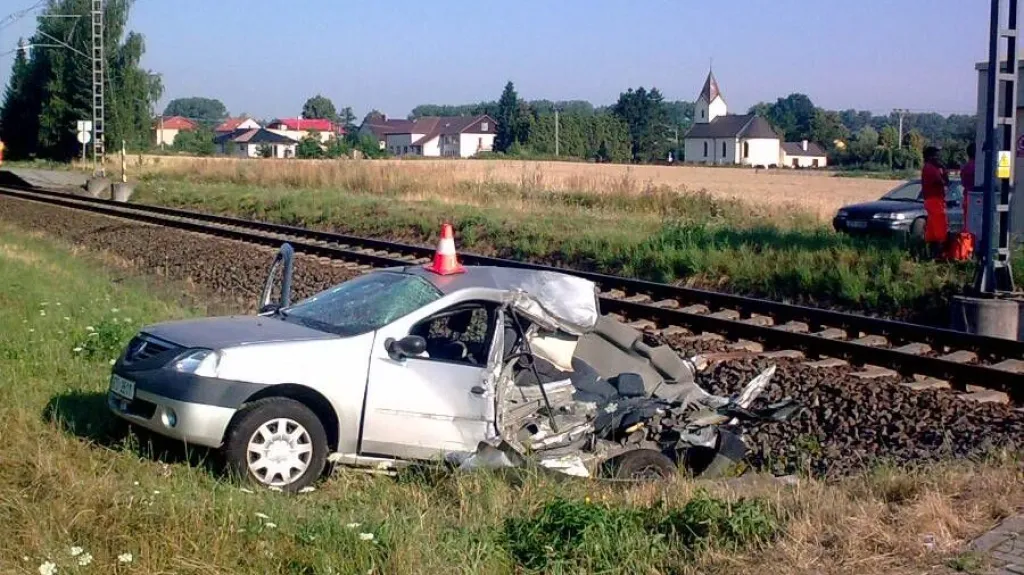 Automobil po srážce s vlakem na Opavsku