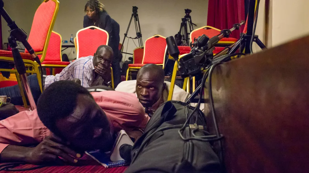 Novináři leží na zemi po střelbě na prezidentský palác v Jižním Súdánu