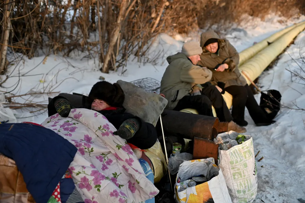 Oleg odpočívá s ostatními lidmi bez domova na teplovodu