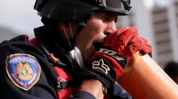 Venezuelský hasič pomocí trubky komunikuje s lidmi uvězněnými pod troskami zřícené budovy