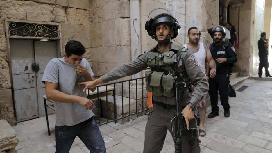 Izraelský policista brání palestinskému mladíkovi ve vstupu do Starého města