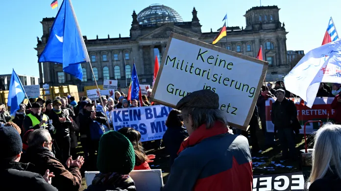 Demonstrant drží plakát s nápisem „Žádná militarizace v německé ústavě“ během protestu proti zvýšení výdajů na obranu před Bundestagem (dolní komora parlamentu) 18. března 2025 v Berlíně