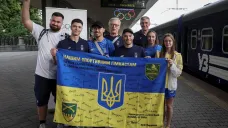 Čás ukrajinských olympioniků před odjezdem na Hry do Paříže s vlajkou s podpisy ukrajinských vojáků
