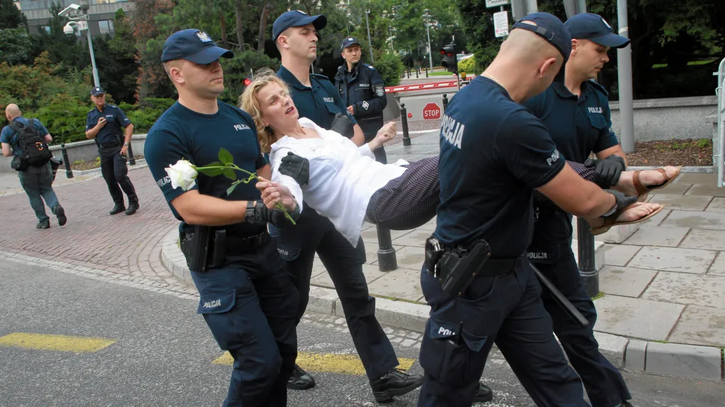Demonstrantku odnáší v Poznani policisté během protestů proti justičním zákonům