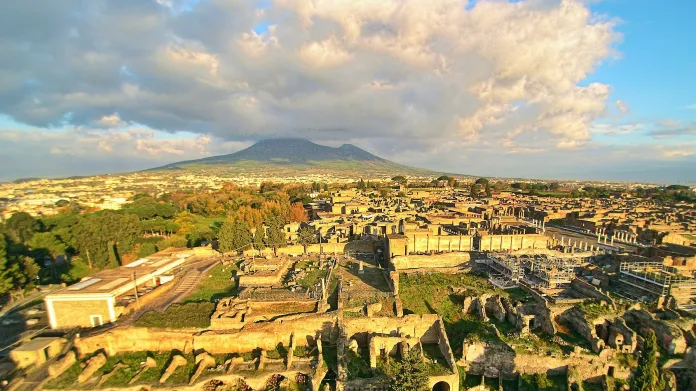 Ruiny Pompejí. V pozadí se tyčí po výbuchu zborcený kužel Vesuvu