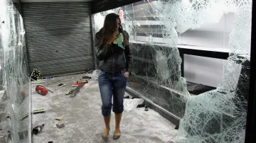 Dívka si prohlíží zničený londýnský obchod