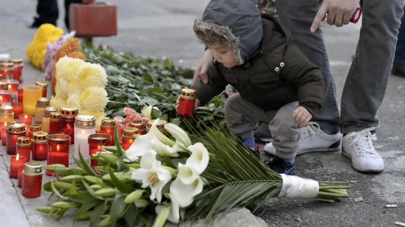 Příbuzní obětí přicházejí položit ke klubu květiny