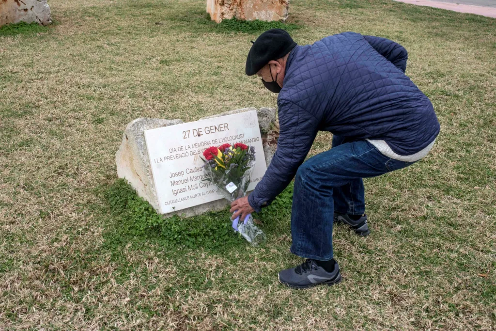 Na pobřežní promenádě v Menorce pokládá pamětník kytici květů k pomníku během vzpomínkové akce menorských obětí nacistického holocaustu. Ti zahynuli převážně v koncentračním táboře Mauthausen
