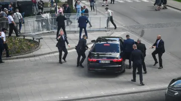 Záběr z momentu krátce po střelbě, kdy se ochranka chystá odvézt Roberta Fica z místa atentátu