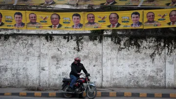 Motorista před volebními transparenty bývalého premiéra Naváze Šarífa