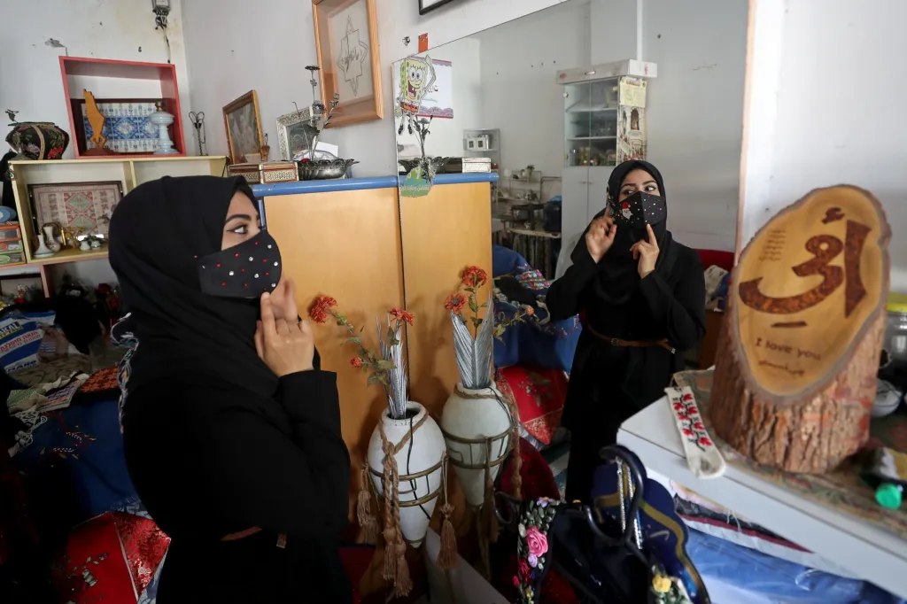 Žena z Palestiny ukazuje ručně vyšívanou masku, kterou si připravila na vánoční oslavy