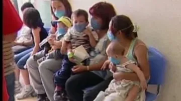 Matky s dětmi chránící se rouškou proti nové chřipce