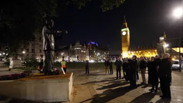 Lidé před sochou Nelsona Mandely na Parliament Square v Londýně