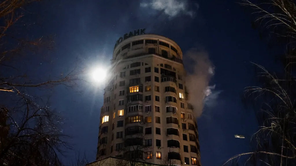 Z ukrajinského bytového domu stoupá kouř poté, co byl zasažen dronem během ruských raketových a dronových útoků, Kyjev
